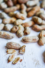 Roasted peanuts on white wooden background