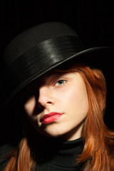 Portrait of a beautiful girl in a black hat