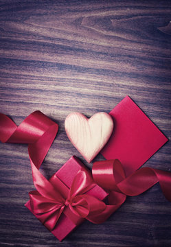 REd Holidays gift and heart on wooden background/ Valentines day