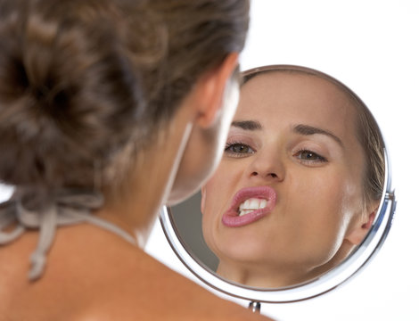 Young Woman Making Funny Faces While Looking In Mirror