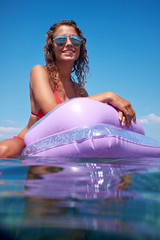 Young perfect woman on an air mattress in the sea