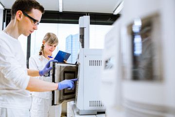 Two young researchers carrying out experiments in a lab