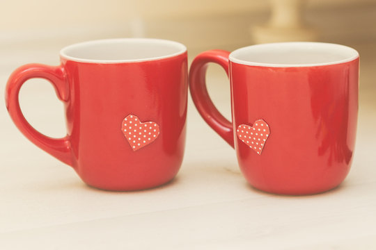 Photo of cute red cups with handmade paper heart