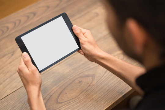 Close-up image of a man using a digital tablet