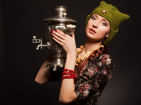 Girl in soviet retro style posing with samovar. Girl with a gree