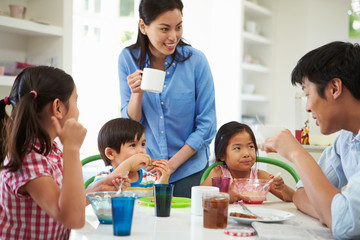 Asian Family Having Breakfast Together In Kitchen