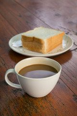coffee cup with sliced bread on wood table