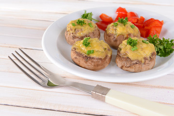Stuffed mushrooms on plate on table on light background