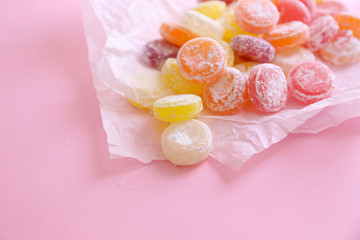 Sweet  multicolor candies on paper, on color background