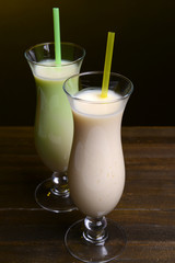 Milk shakes on table on black background