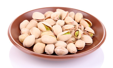 Pistachio nuts on plate isolated on white