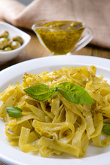 Delicious pasta with pesto on plate on table close-up