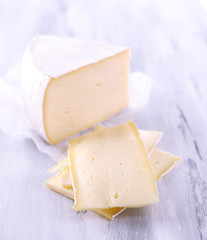 Tasty Camembert cheese, on wooden table