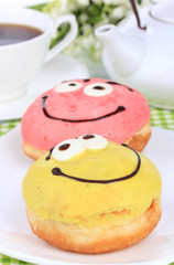 Sweet donuts with cup of tea on table close-up
