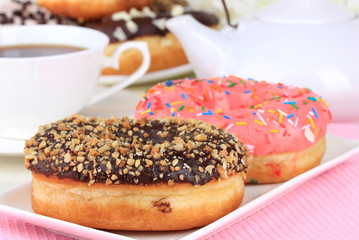 Sweet donuts with cup of tea on table close-up