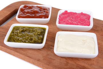 Various sauces on chopping board on table close-up