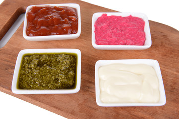 Various sauces on chopping board on table close-up