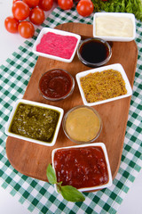 Various sauces on chopping board on table close-up