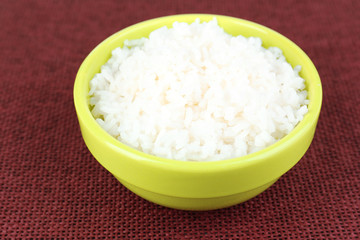 Cooked rice in bowl on red background