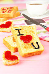 Delicious toast with jam and cup of tea on table close-up