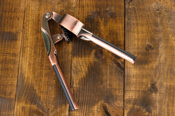 Garlic press on wooden background