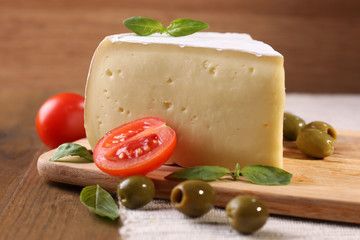 Tasty Camembert cheese with tomatoes, olives and basil,