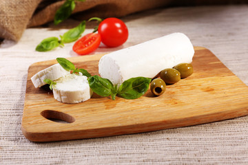 Tasty bushe cheese with tomatoes, olives and basil,