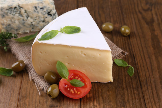 Tasty Camembert cheese with tomato, basil and olives,