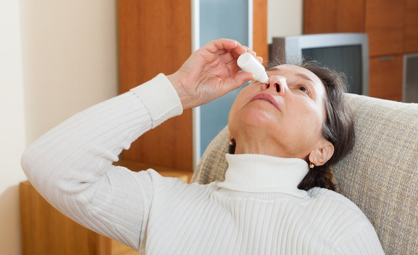 Mature woman dripping nasal drops