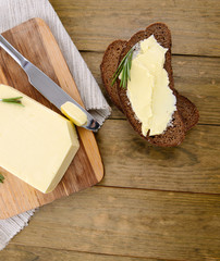 Slice of rye bread with butter on wooden table