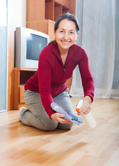 mature housewife polishing parquet floor