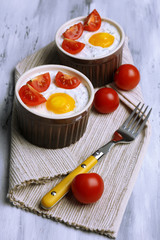 Baked eggs on wooden table close up