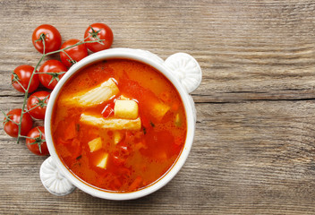 Bowl of tomato soup on wooden table