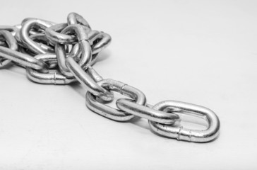 Obraz premium metal chain folded in a heap on white