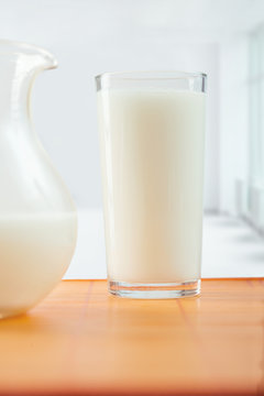 glass of milk and pitcher on table