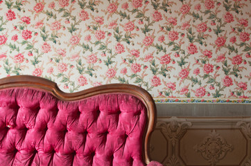 Old damaged red couch in an antique house. Flowers wallpaper - 61238548