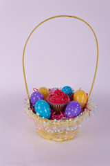 Fototapeta na wymiar Basket with Easter eggs and cupcake