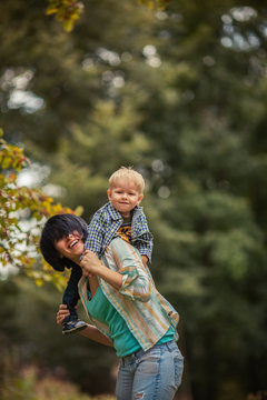 Mother playing with her son and lifting him rejoicing