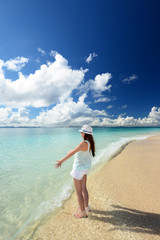 Fototapeta na wymiar 南国沖縄の美しいビーチで寛ぐ女性