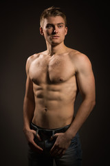 Strong athletic man on dark background