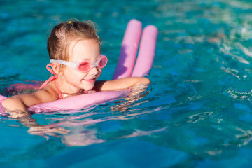 Fototapeta na wymiar Little girl at swimming pool