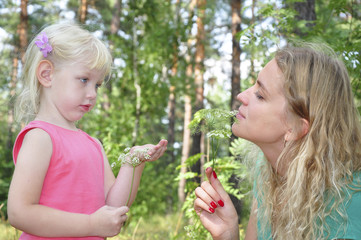 Mom with her daughter in the summer woods.