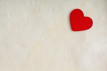 Obraz premium Red wooden decorative heart on white cloth background.