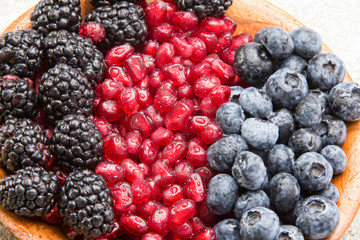 Closeup of juicy mixed berries in a wooden bowl