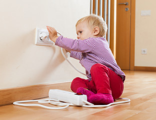 Toddler playing with electrical extension