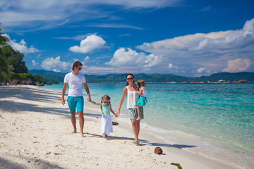 Young beautiful family with two kids on tropical vacation