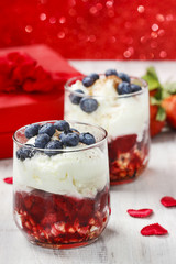 Layer strawberry, blueberry and muesli dessert in glass goblet