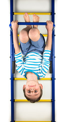 Boy hanging upside down on a white background