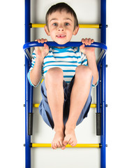 Child hanging on a horizontal bar on a white background