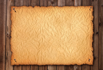 Old  wrinkly paper on brown aged wood. Old paper sheet. Digital